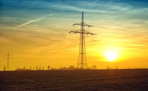 Strommasten mit Sonne im Hintergrund